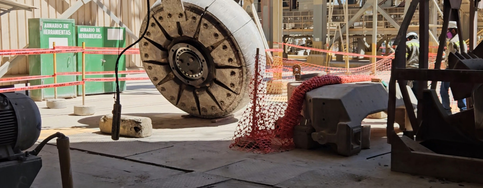 Gran pieza industrial circular sobre piso de concreto durante una tarea de mantenimiento en planta